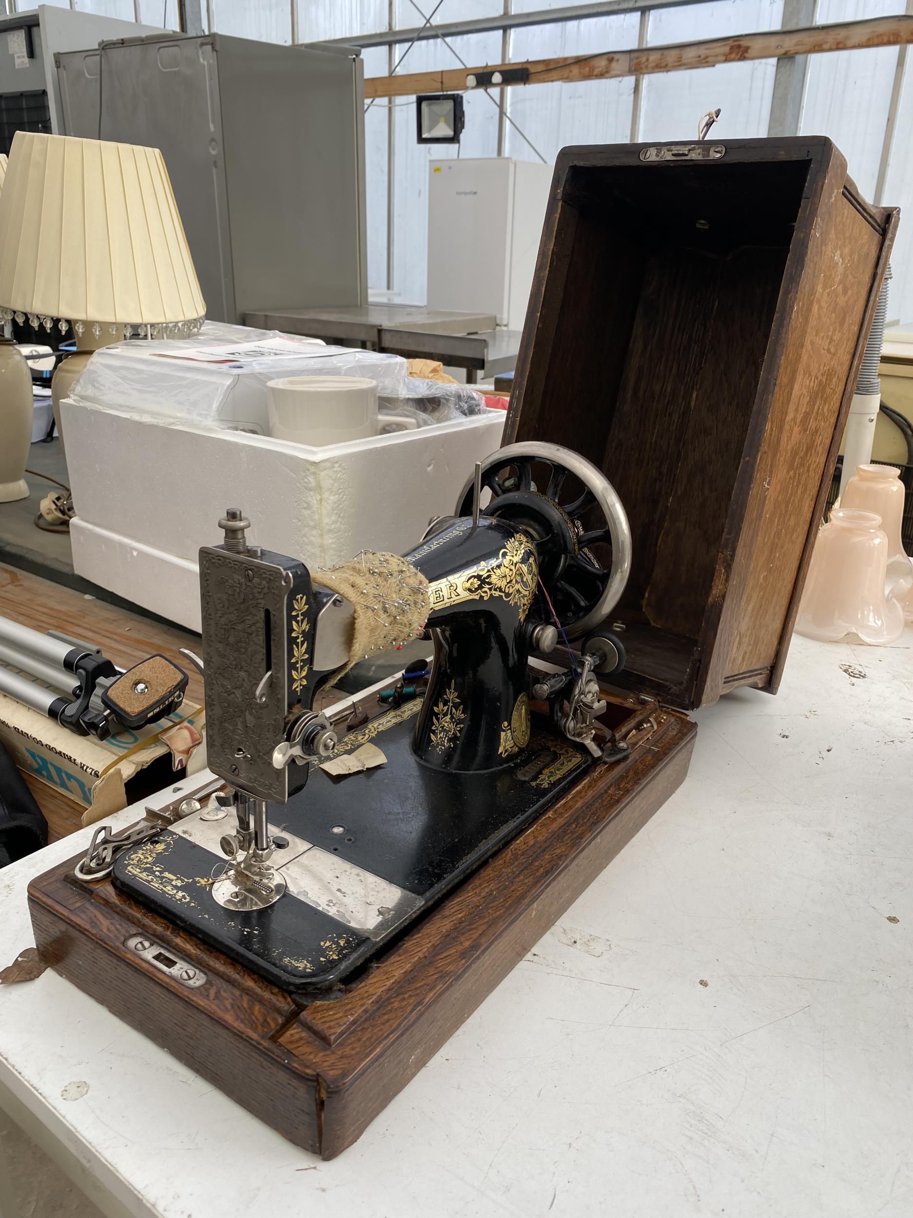 A VINTAGE SINGER SEWING MACHINE WITH WOODEN CARRY CASE