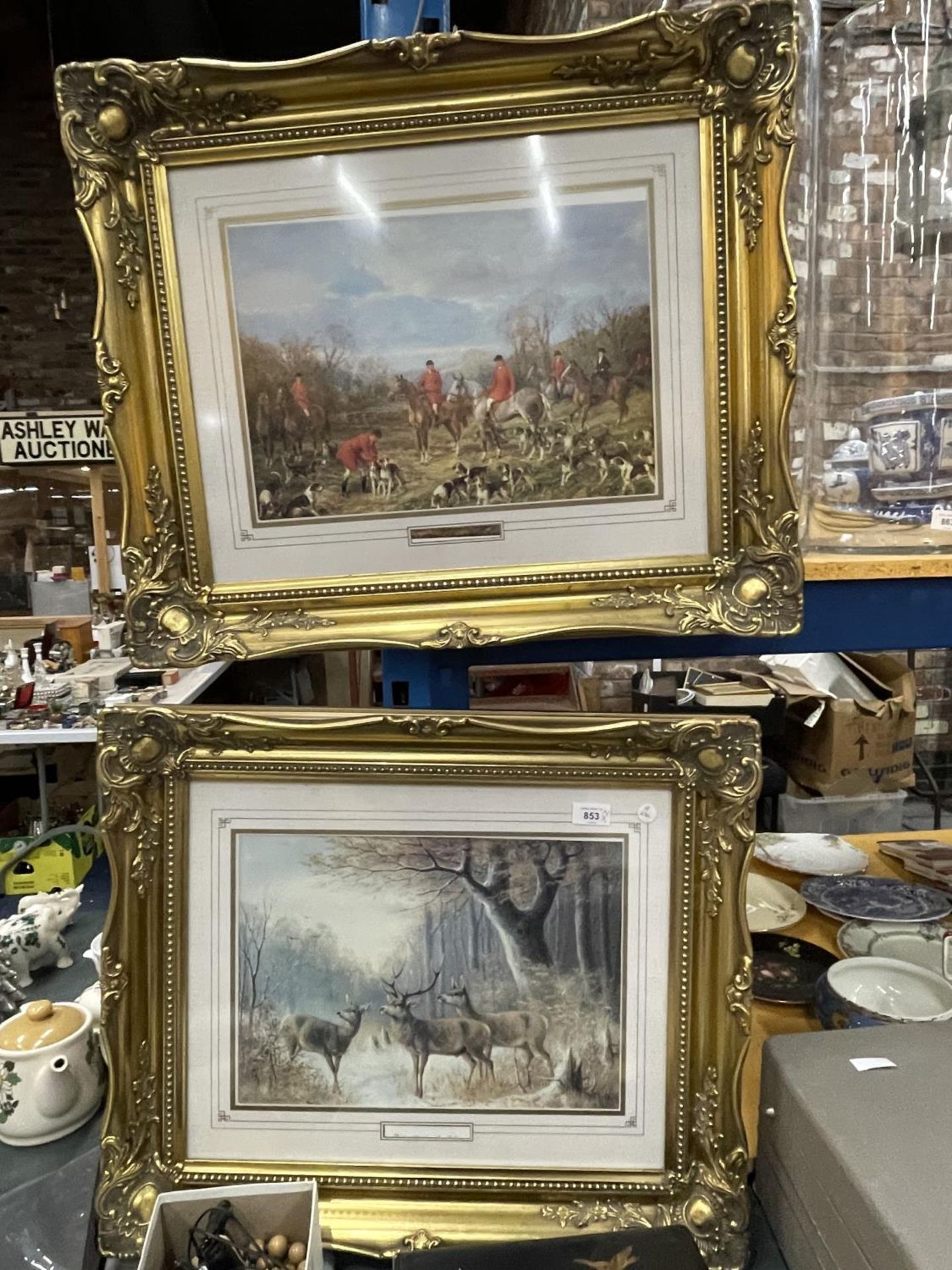 TWO GILT FRAMED PRINTS ONE OF DEER IN A WOODLAND SETTING, THE OTHER A HUNTING SCENE