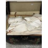 A LARGE VINTAGE TRAVELLING TRUNK CONTAINING A SUBSTANTIAL QUANTITY OF VINTAGE LINEN