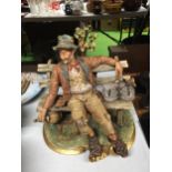 A CAPODIMONTE FIGURE OF A DRUNKEN TRAMP ON A BENCH DRINKING WINE