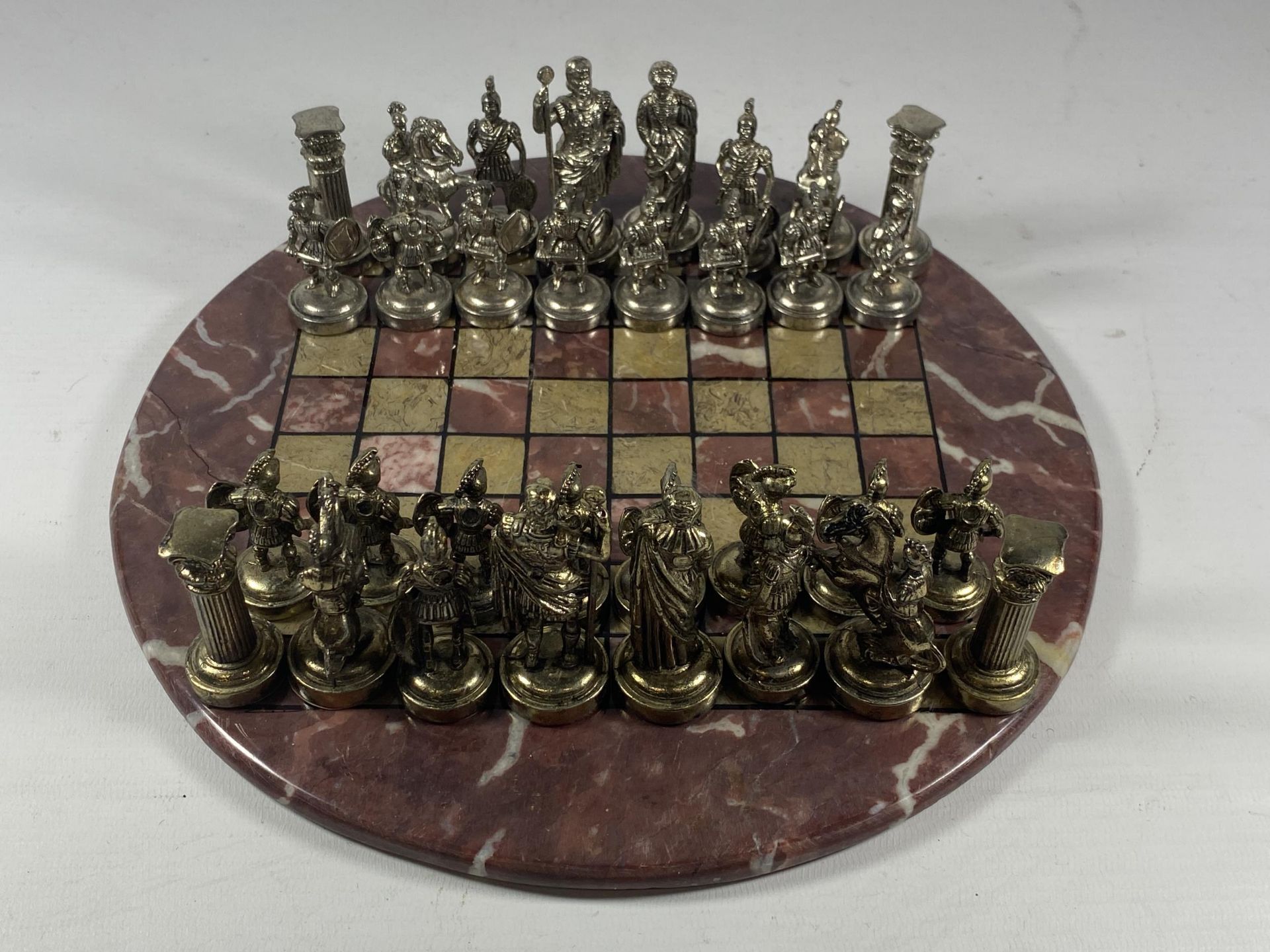 A METAL WARRIOR CHESS SET ON MARBLE BASE, BOARD DIAMETER 26CM