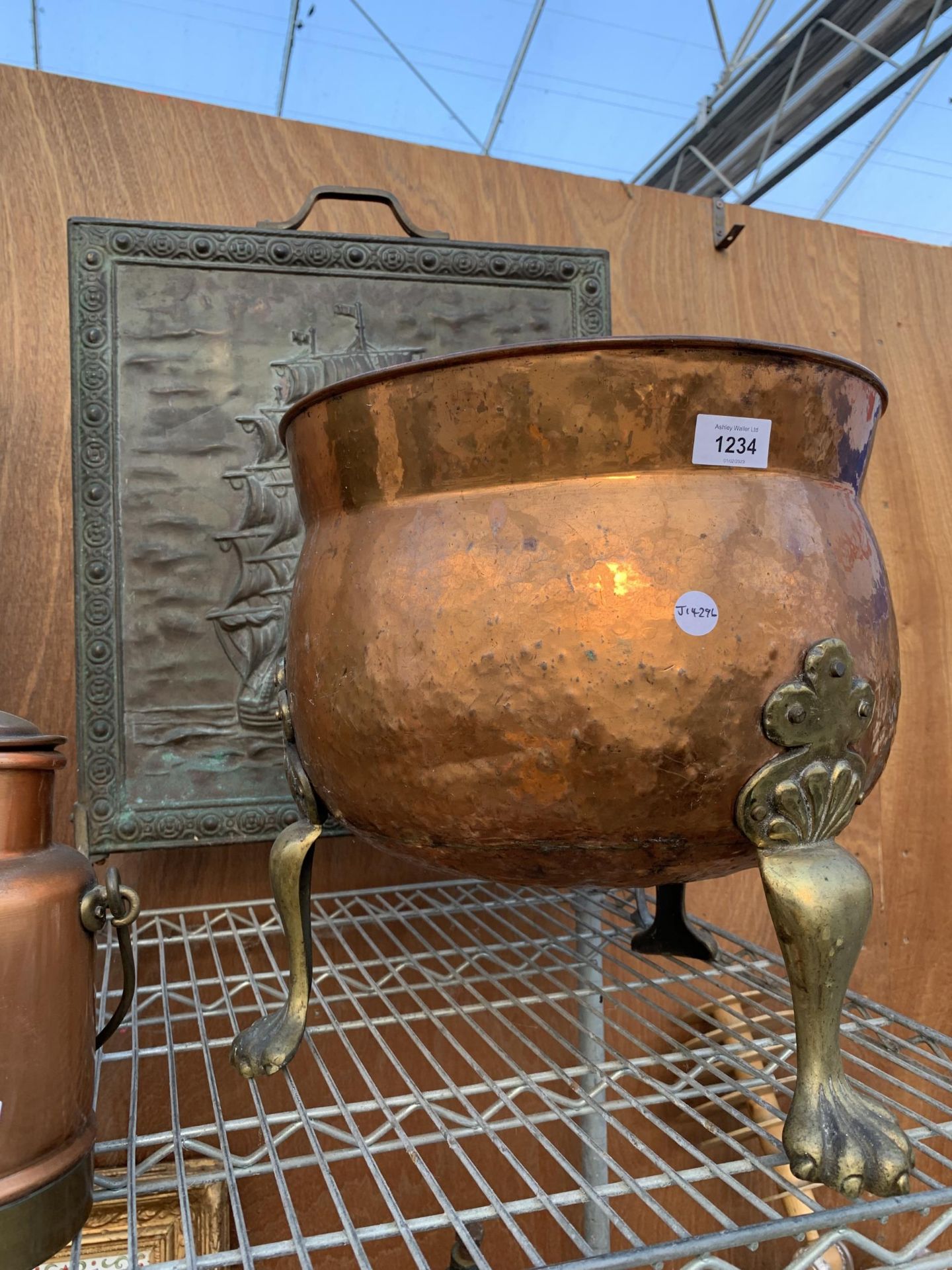 A VINTYAGE COPPER COAL BUCKET ON BRASS LION PAW FEET AND A FURTHER BRASS FIRE SCREEN