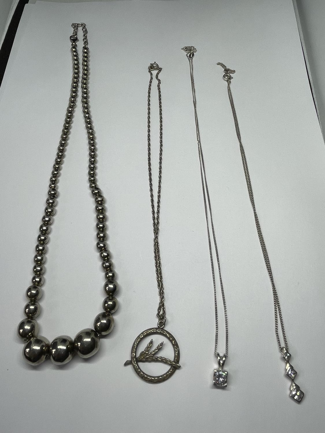 FOUR SILVER NECKLACES ONE BALL DESIGN AND THREE WITH PENDANTS