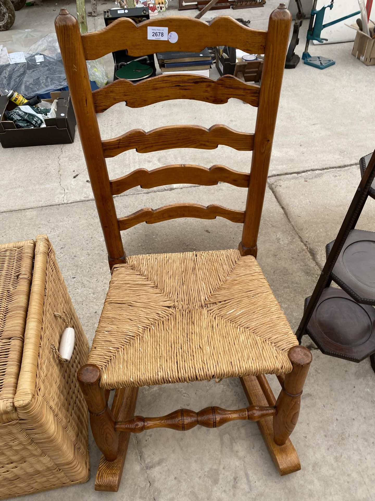 A 19TH CENTURY STYLE ELM ROCKING CHAIR WITH LADDERBACK AND RUSH SEAT