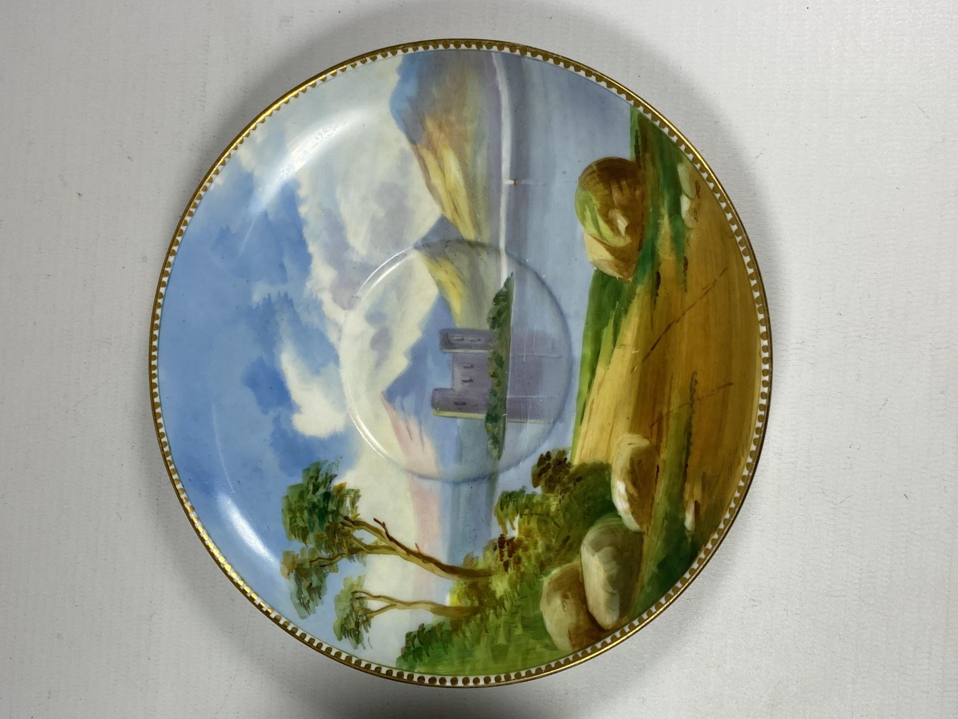 A 19TH CENTURY HAND PAINTED PORCELAIN CUP AND SAUCER WITH LAKE & CASTLE SCENE, CROSS/WING MARK TO - Image 2 of 5