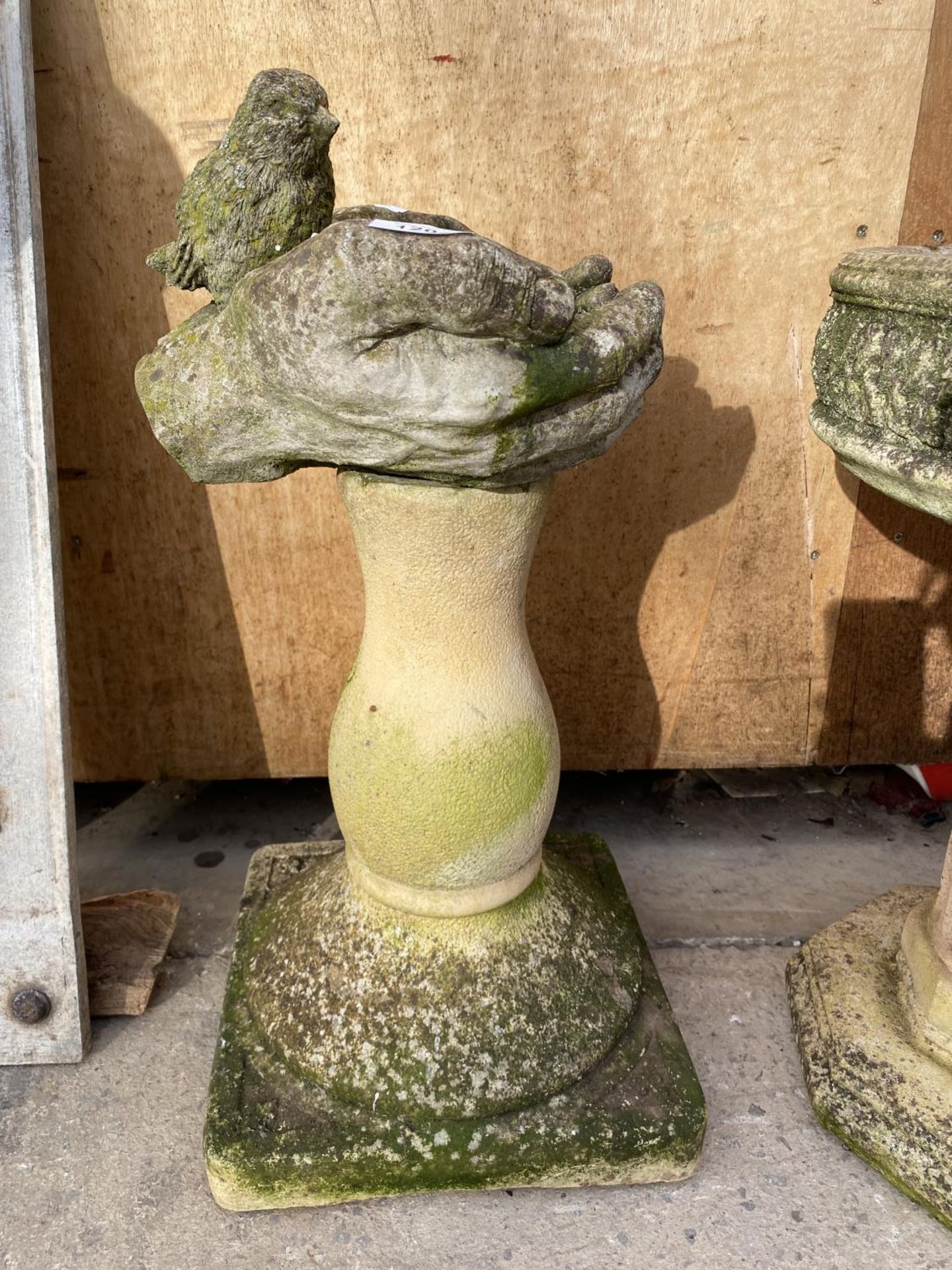A RECONSTITUTED STONE BIRD BATH IN THE FORM OF TWO HANDS ON A PEDESTAL BASE (H:55CM)
