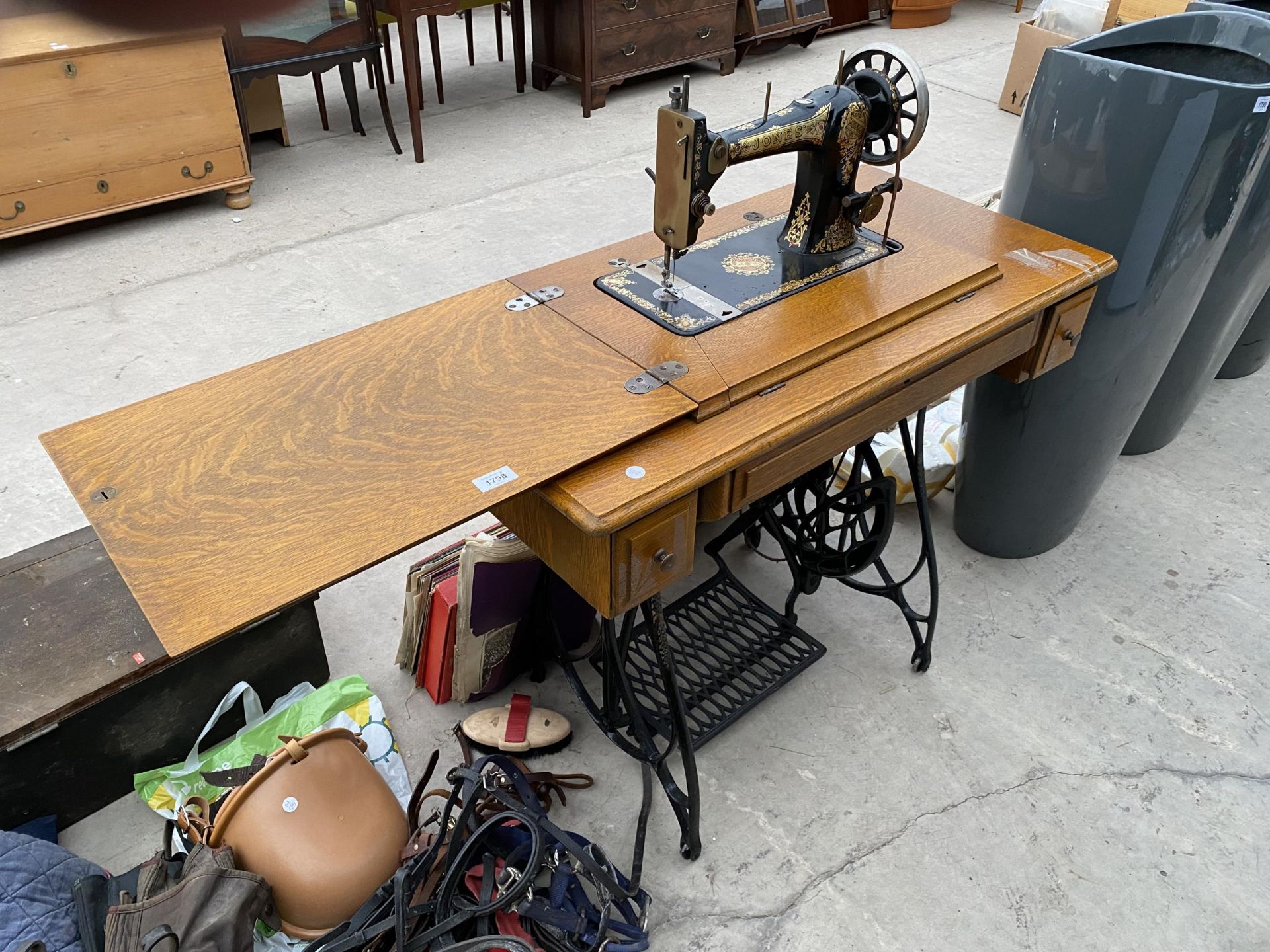 A JONES TREADLE SEWING MACHINE WITH CAST IRON BASE