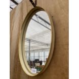 AN OVAL CREAM FRAMED WALL MIRROR