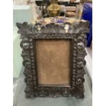 A WOODEN CARVED PHOTO FRAME 28CM X 23CM