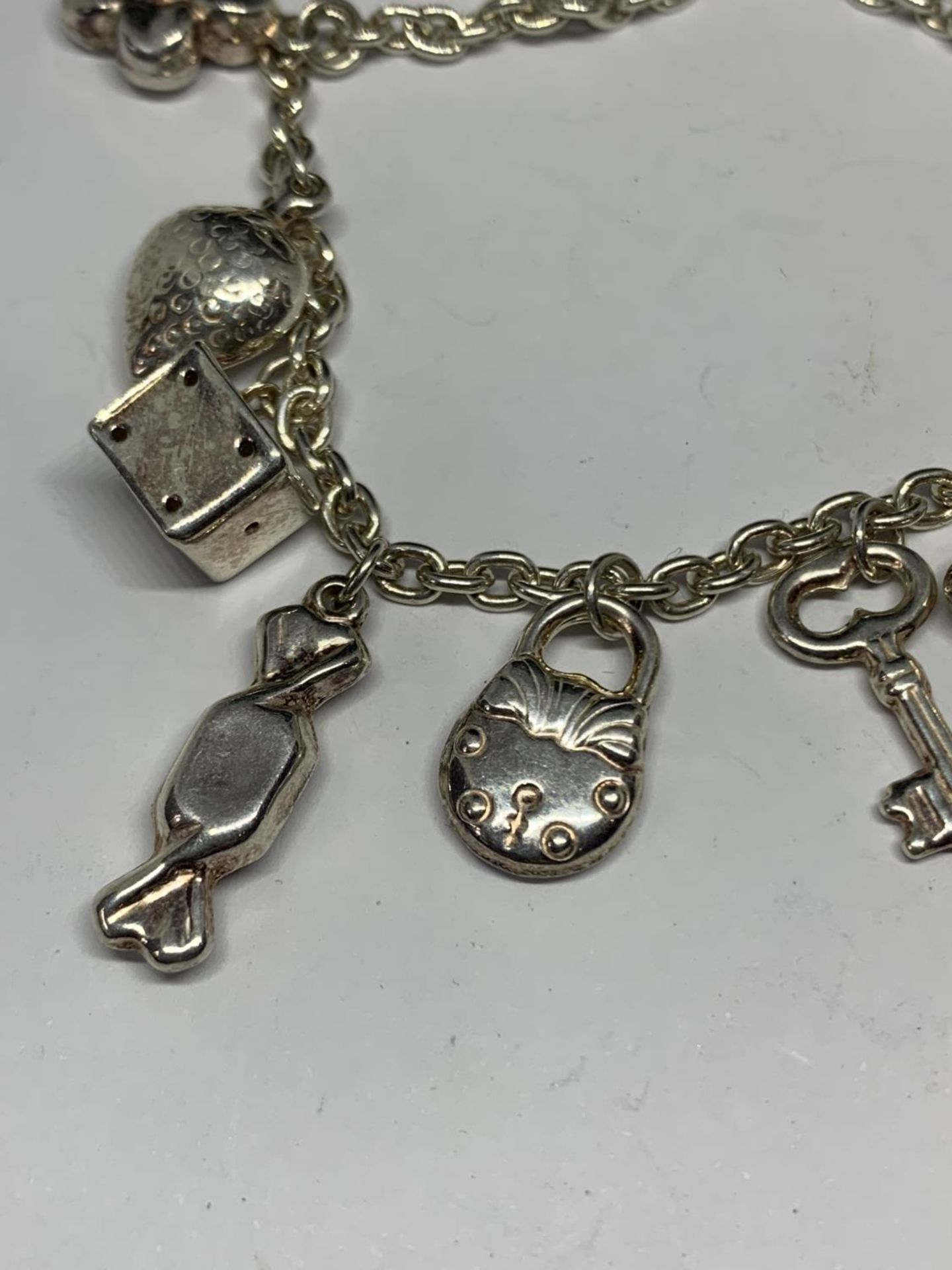 A SILVER BRACELET WITH ELEVEN CHARMS - Image 2 of 4