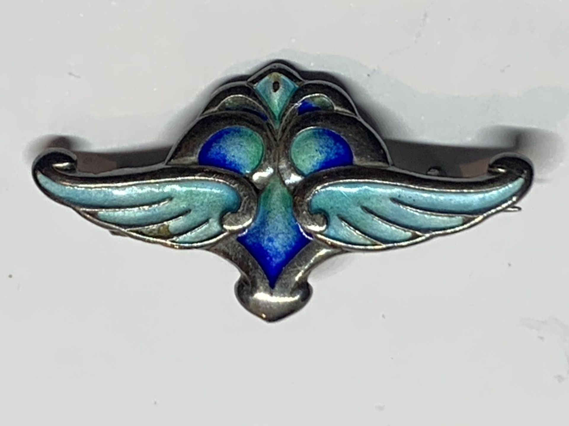 AN ART NOUVEAU HALLMARKED SILVER AND ENAMELLED WING DESIGN BROOCH