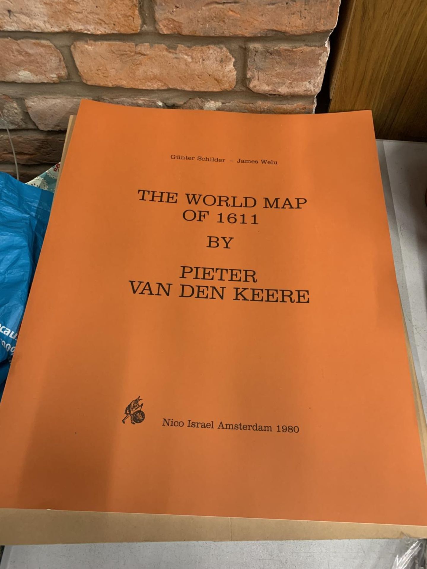 A LARGE PAPERBACK ENTITLED 'THE WORLD MAP OF 1611' BY PIETER VAN DEN KEERE PUBLISHED IN 1980