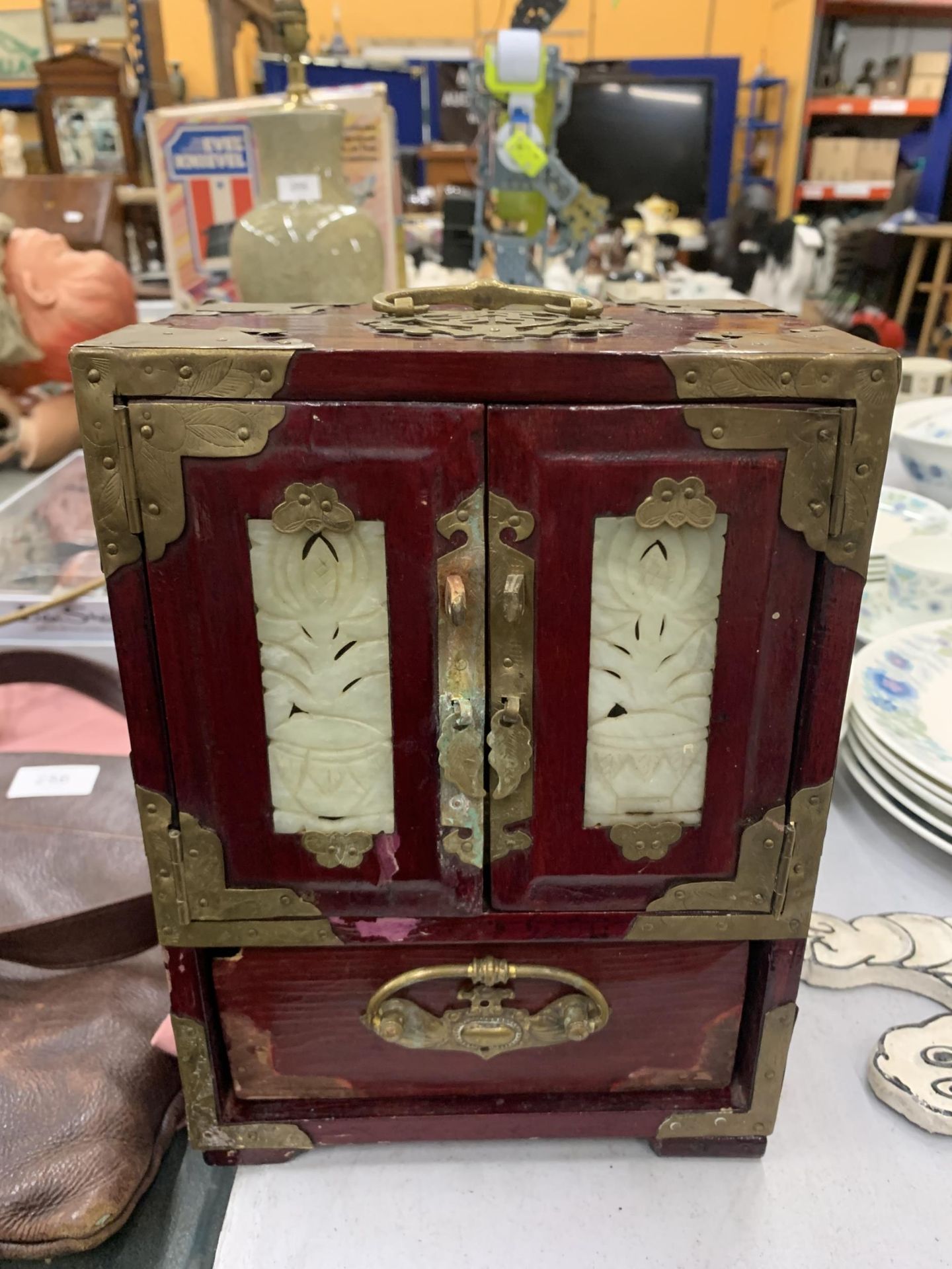 AN ORIENTAL STYLE RED CABINET WITH METAL FITTINGS HEIGHT 24CM, WIDTH 18CM, DEPTH 13CM