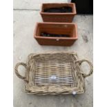 A WICKER BASKET AND TWO TERRACOTTA PLANTERS