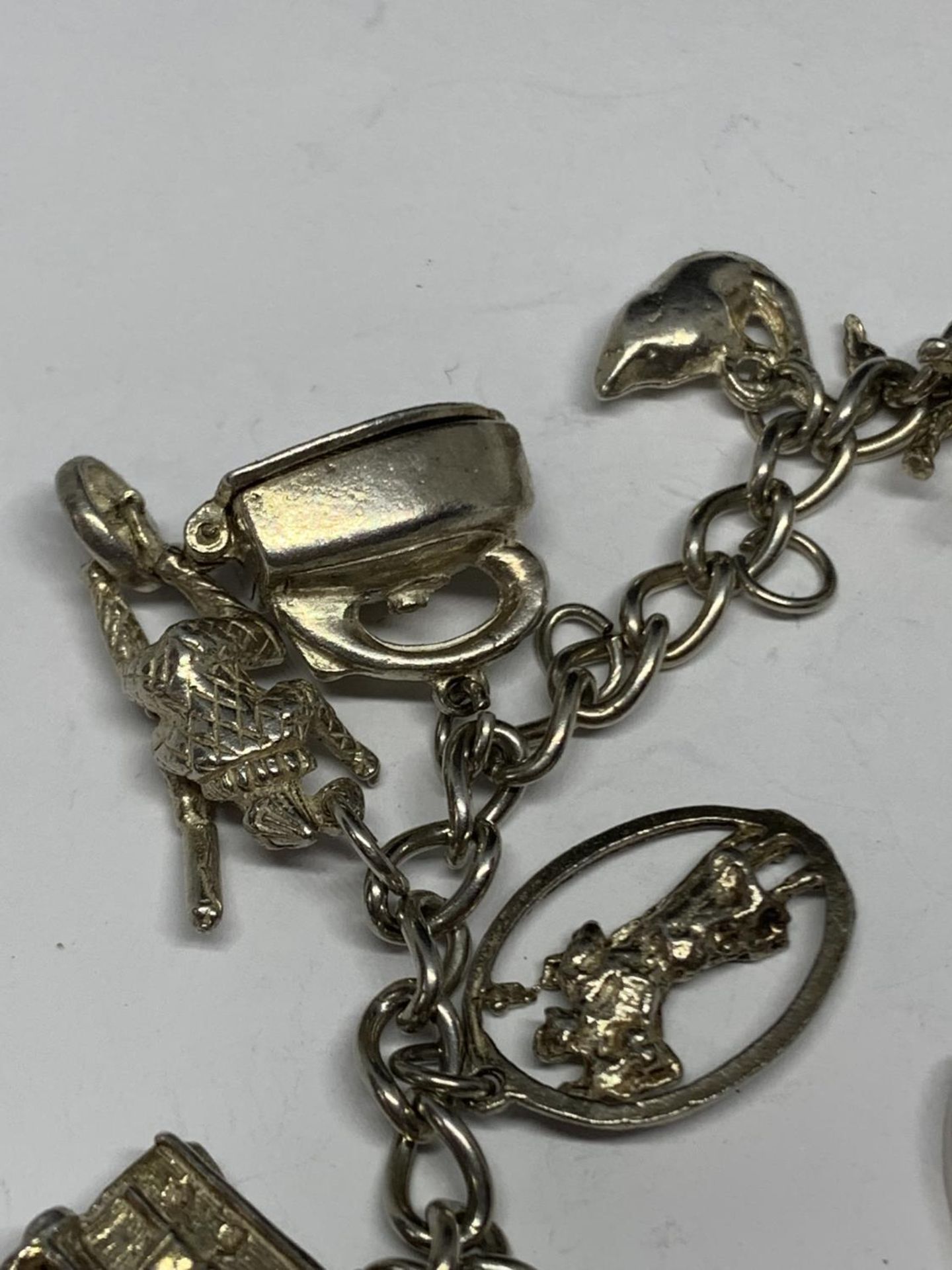 A SILVER BRACELET WITH THIRTEEN CHARMS - Image 2 of 4