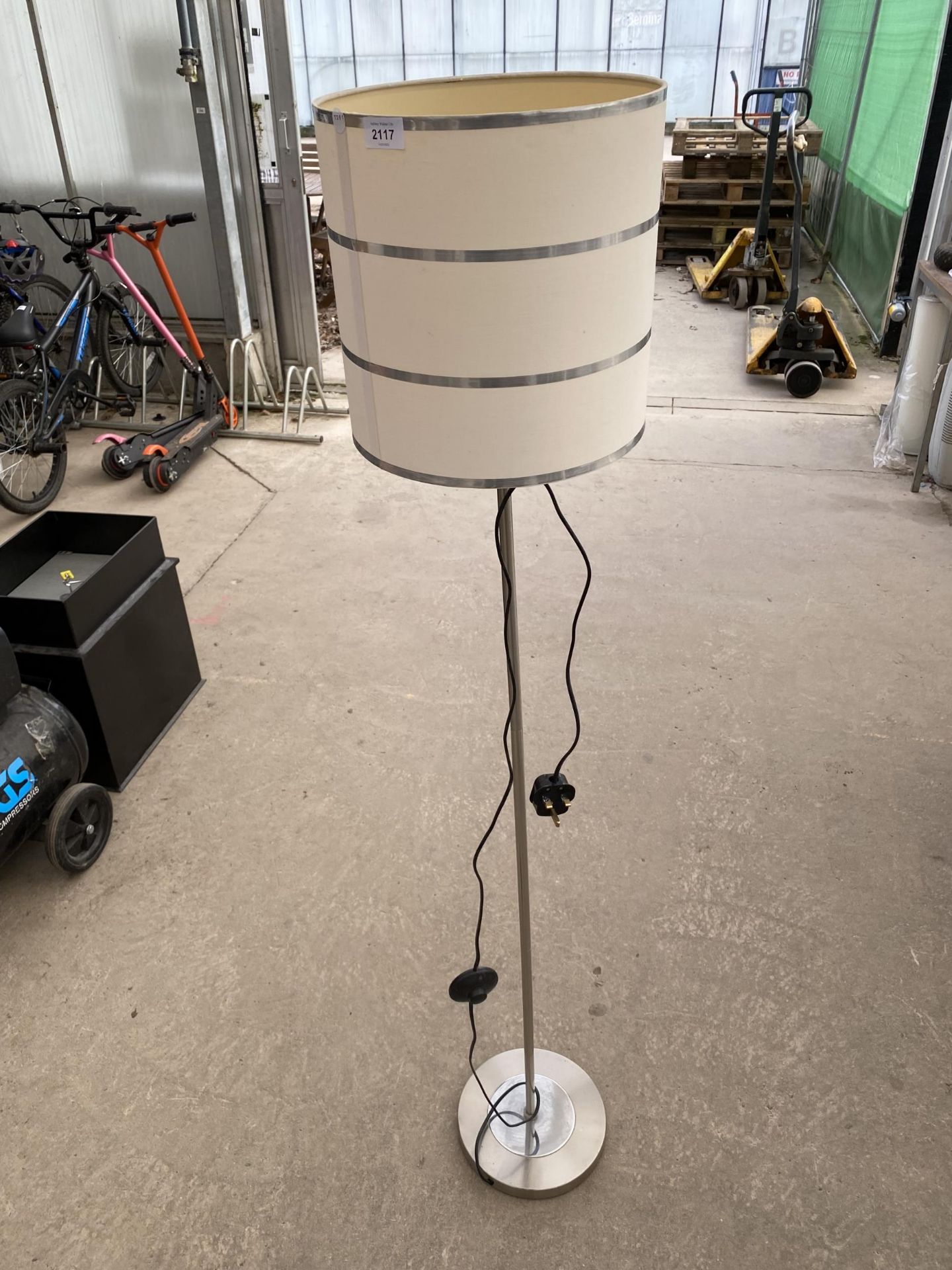 A METAL FLOOR LAMP WITH CREAM SHADE