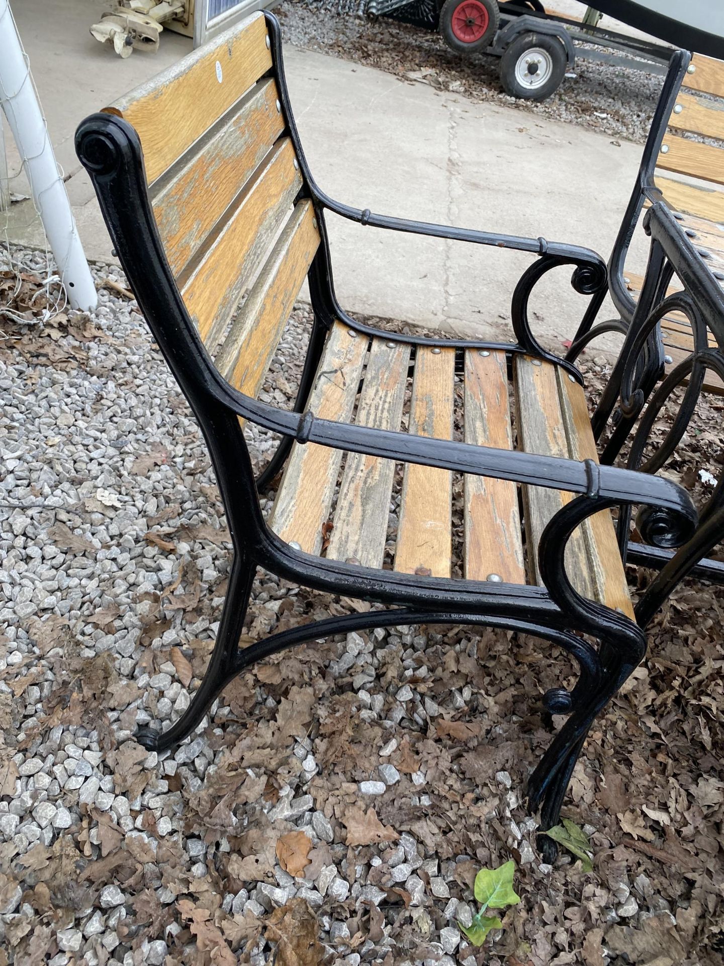 A WOODEN SLATTED PATIO FURNITURE SET WITH CAST TABLE BASE, TWO BENCHES AND TWO CHAIRS WITH CAST ENDS - Image 3 of 7