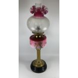 A VINTAGE BRASS CORINTHIAN COLUMN OIL LAMP WITH PINK GLASS RESEVOIR, HEIGHT 67CM