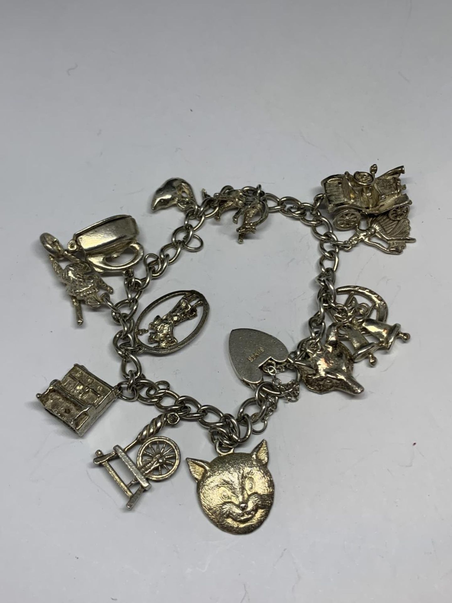 A SILVER BRACELET WITH THIRTEEN CHARMS