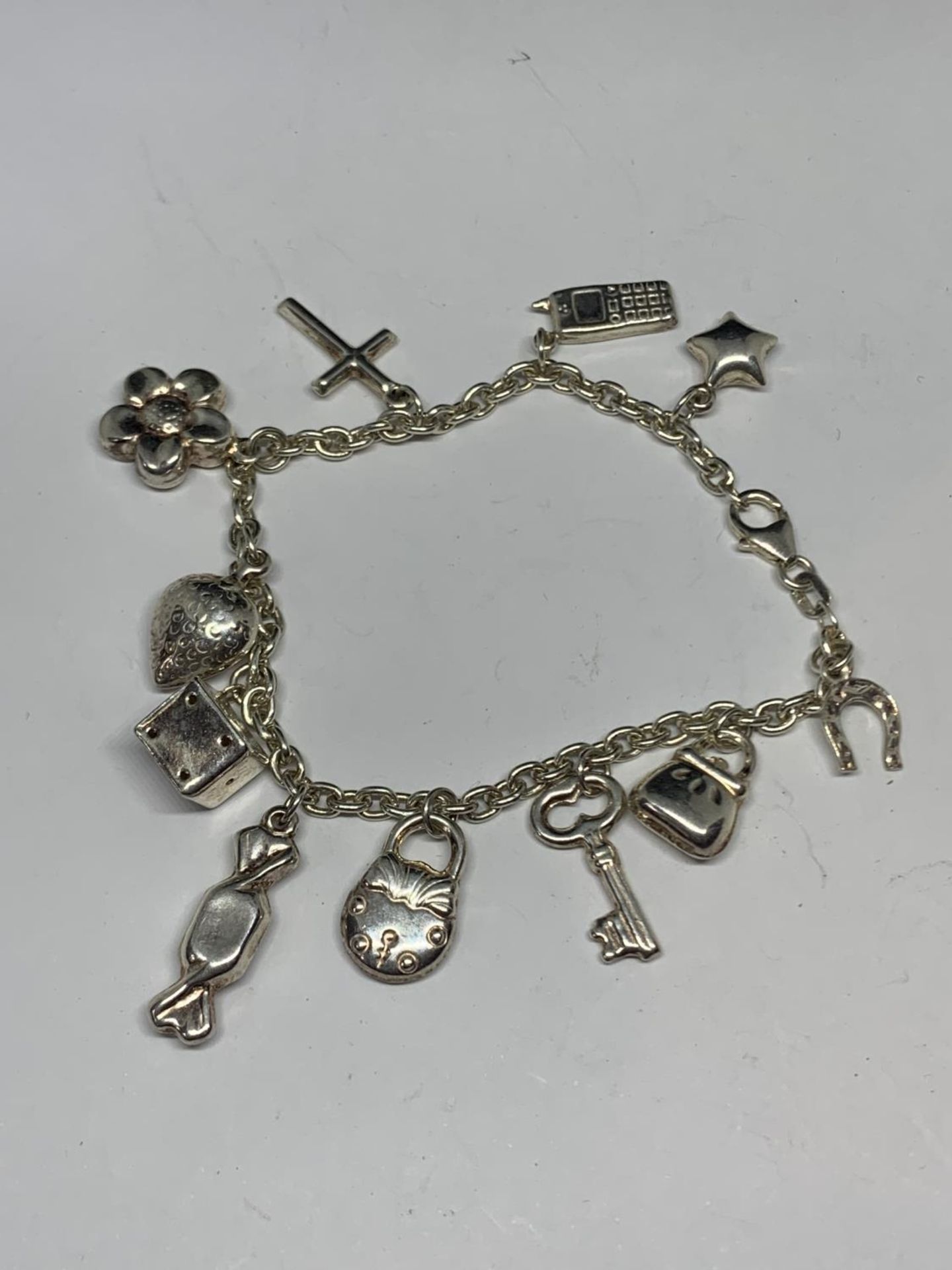 A SILVER BRACELET WITH ELEVEN CHARMS