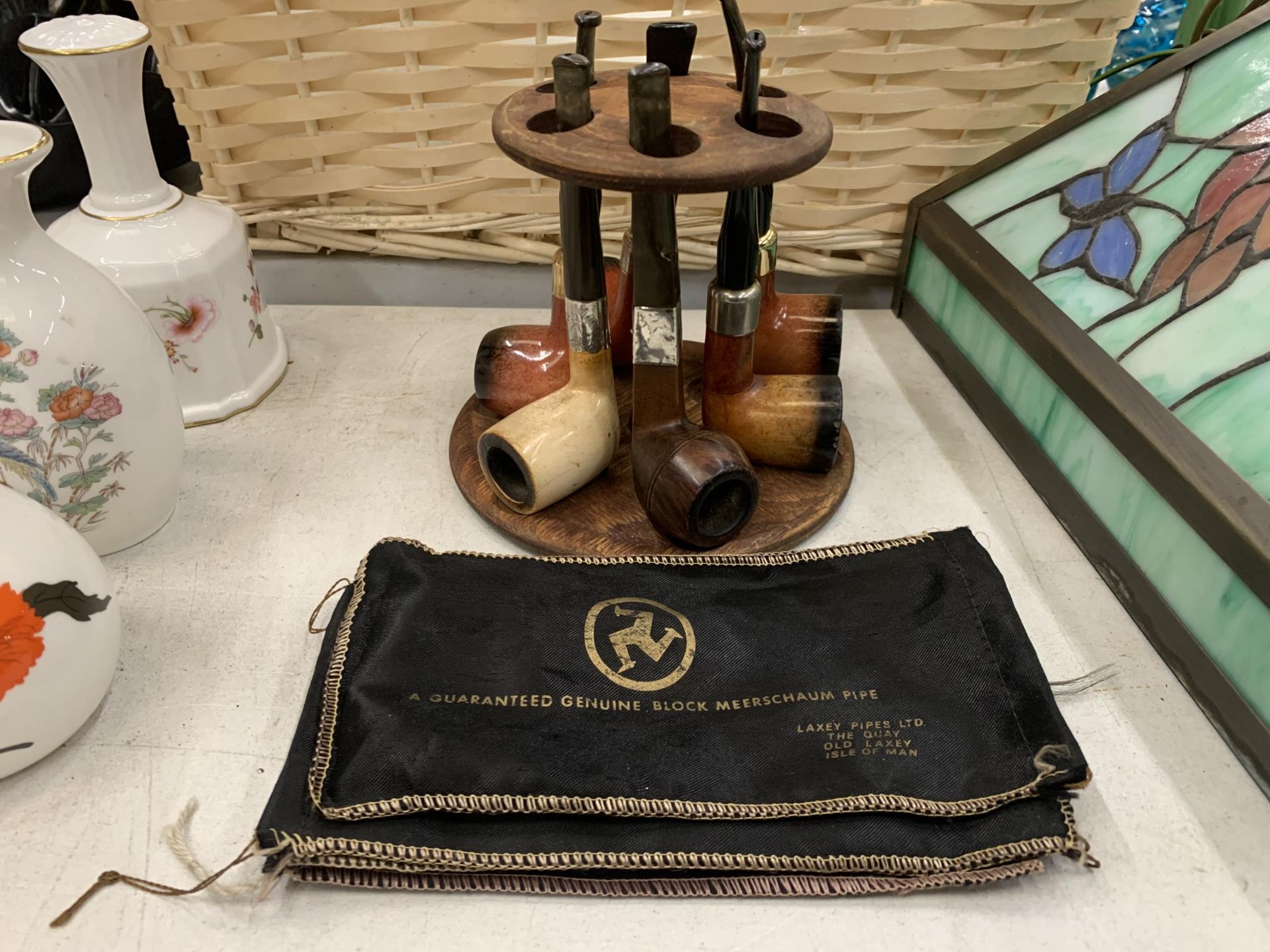 A WOODEN PIPE STAND CONTAINING SIX PIPES - TWO WITH SILVER COLLARS - PLUS FOUR LAXEY PIPES BLOCK