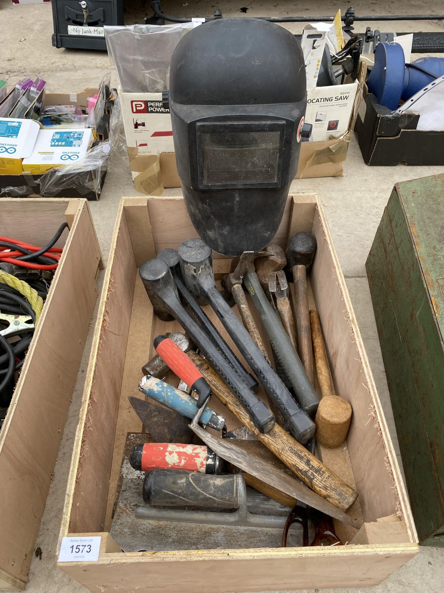 AN ASSORTMENT OF TOOLS TO INCLUDE A WELDING MASK, HAMMERS AND TROWELS ETC