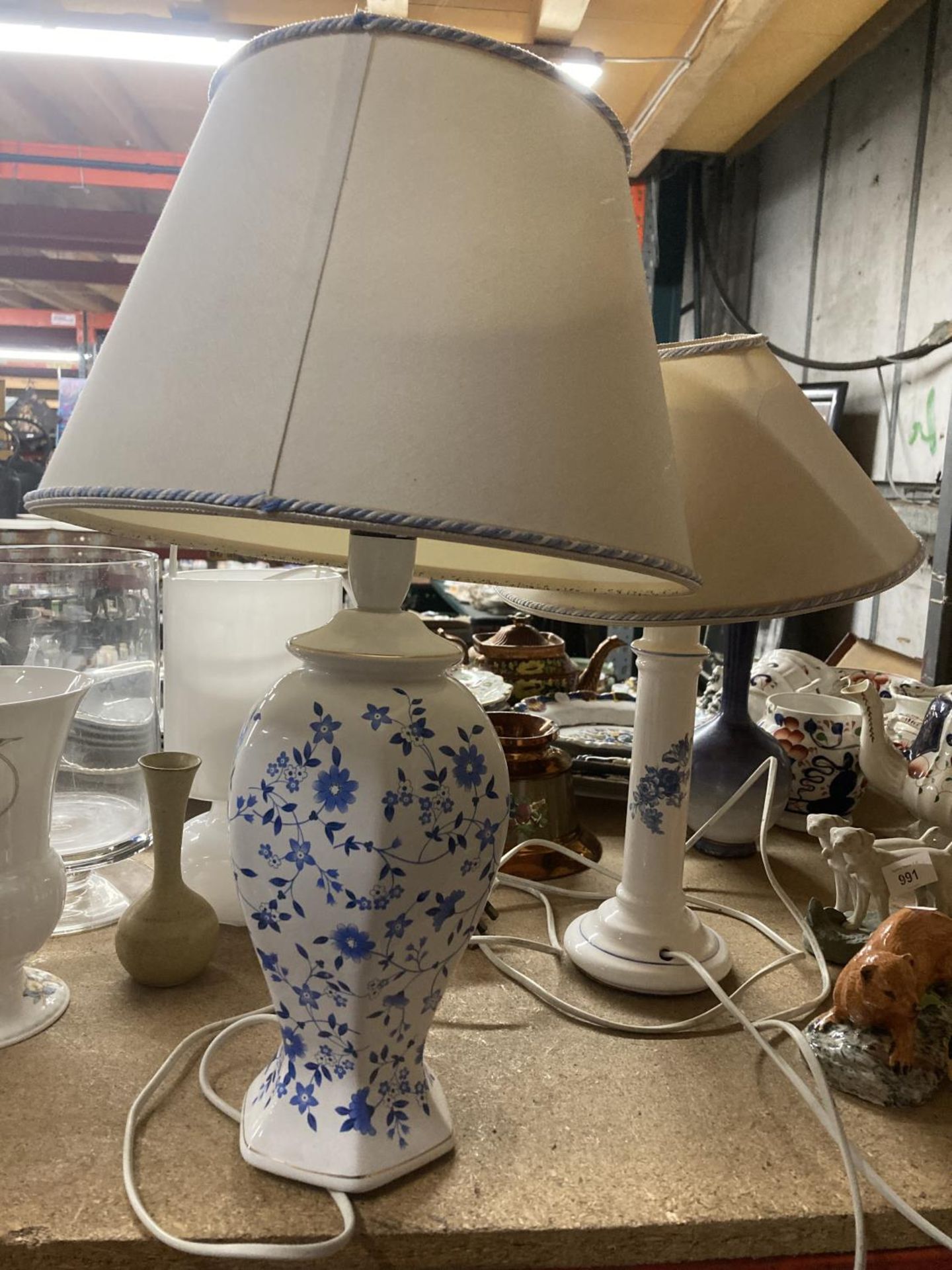 TWO CERAMIC BLUE AND WHITE FLORAL LAMPS WITH CREAM AND BLUE AND WHITE TRIM SHADES