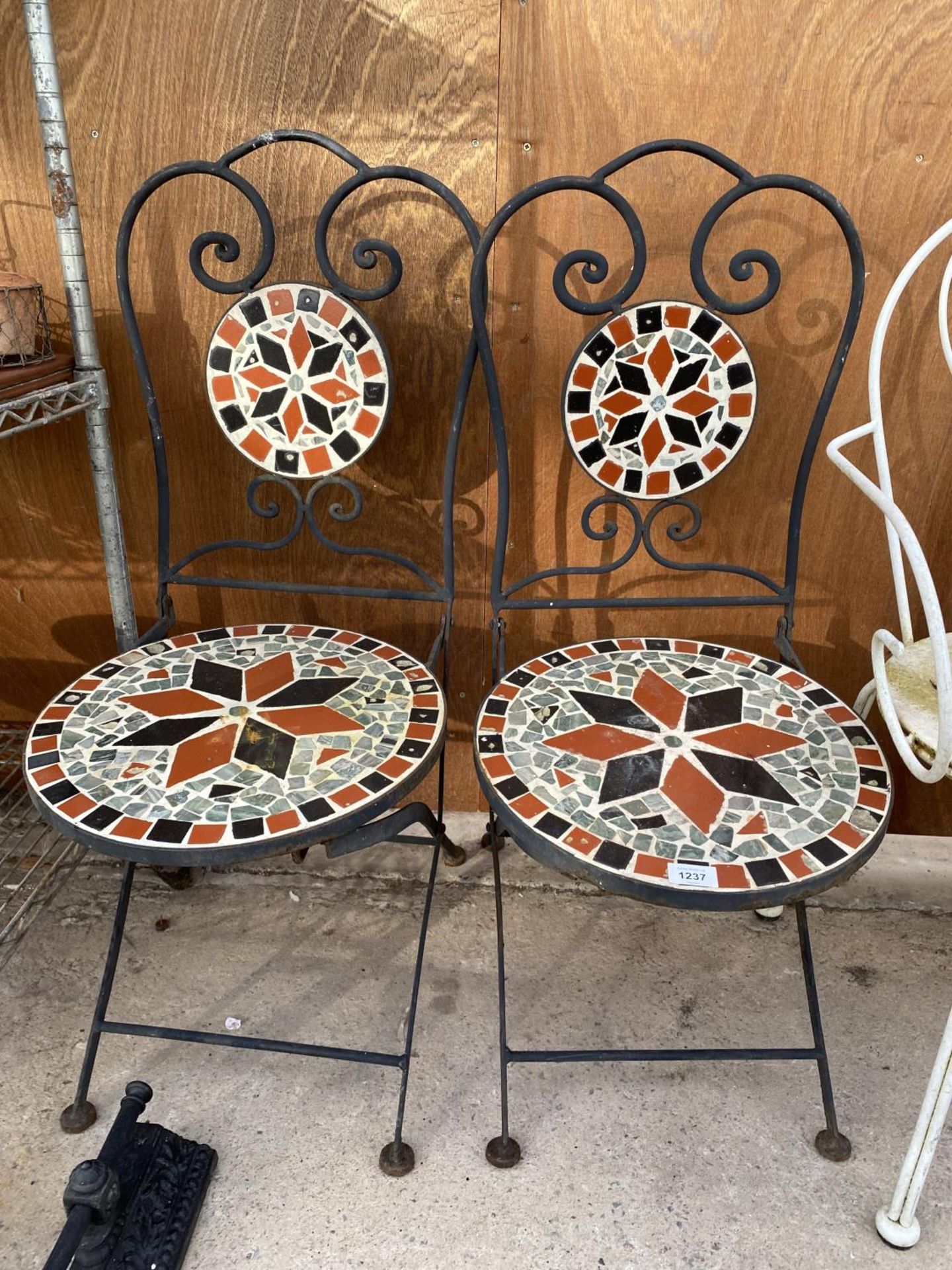 A PAIR OF WORUGHT IRON AND TILED FOLDING GARDEN CHAIRS