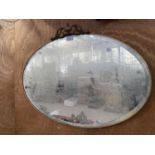 AN OVAL BEVELED EDGE WALL MIRROR WITH BRASS FRAME