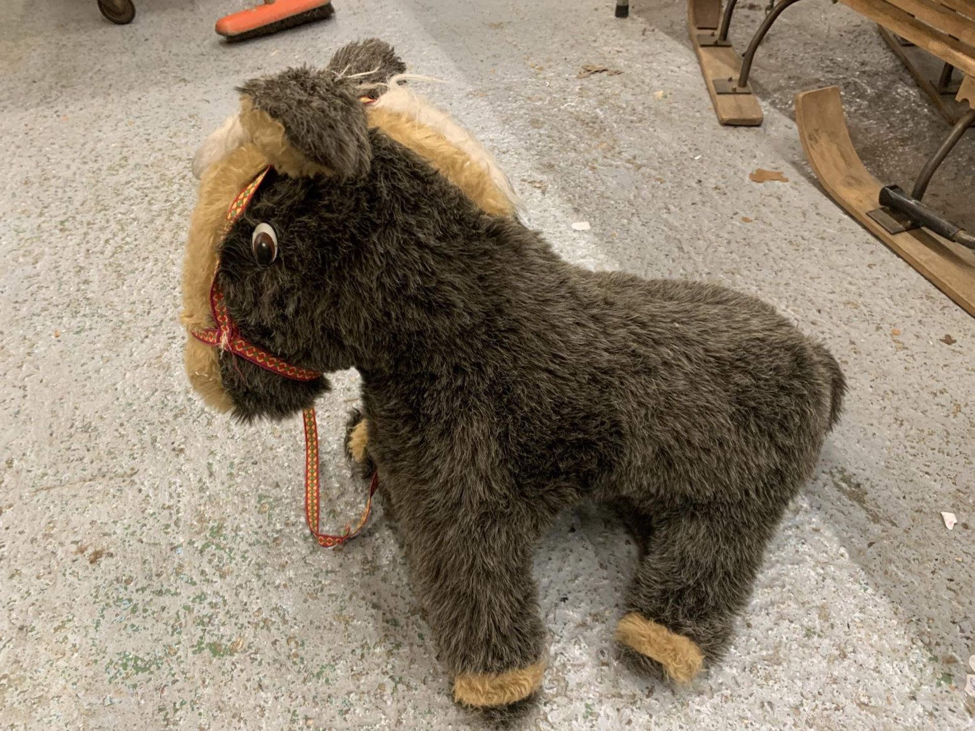 A LARGE SOFT TOY DONKEY WITH REINS