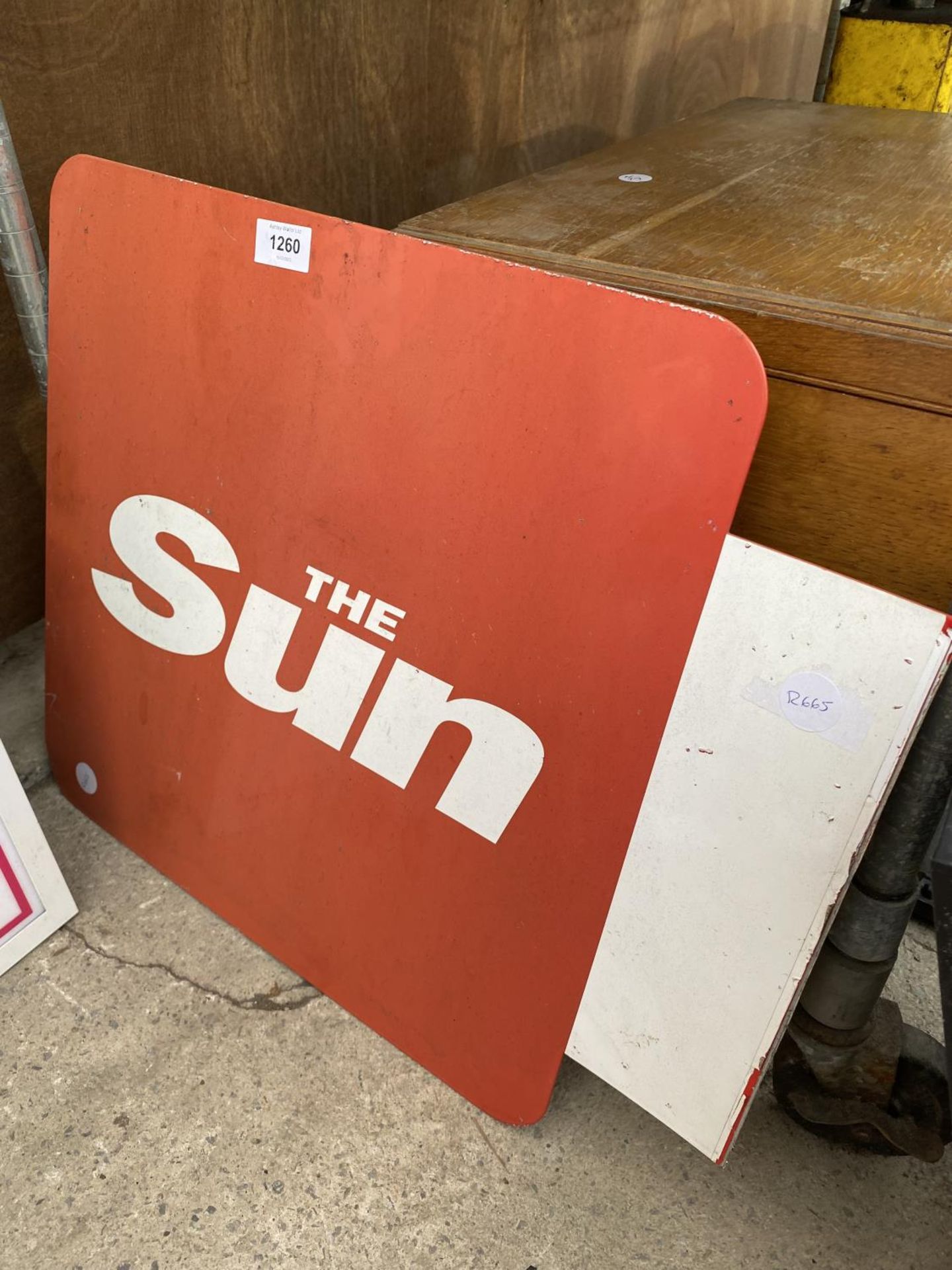 A METAL SUN NEWSPAPER SIGN