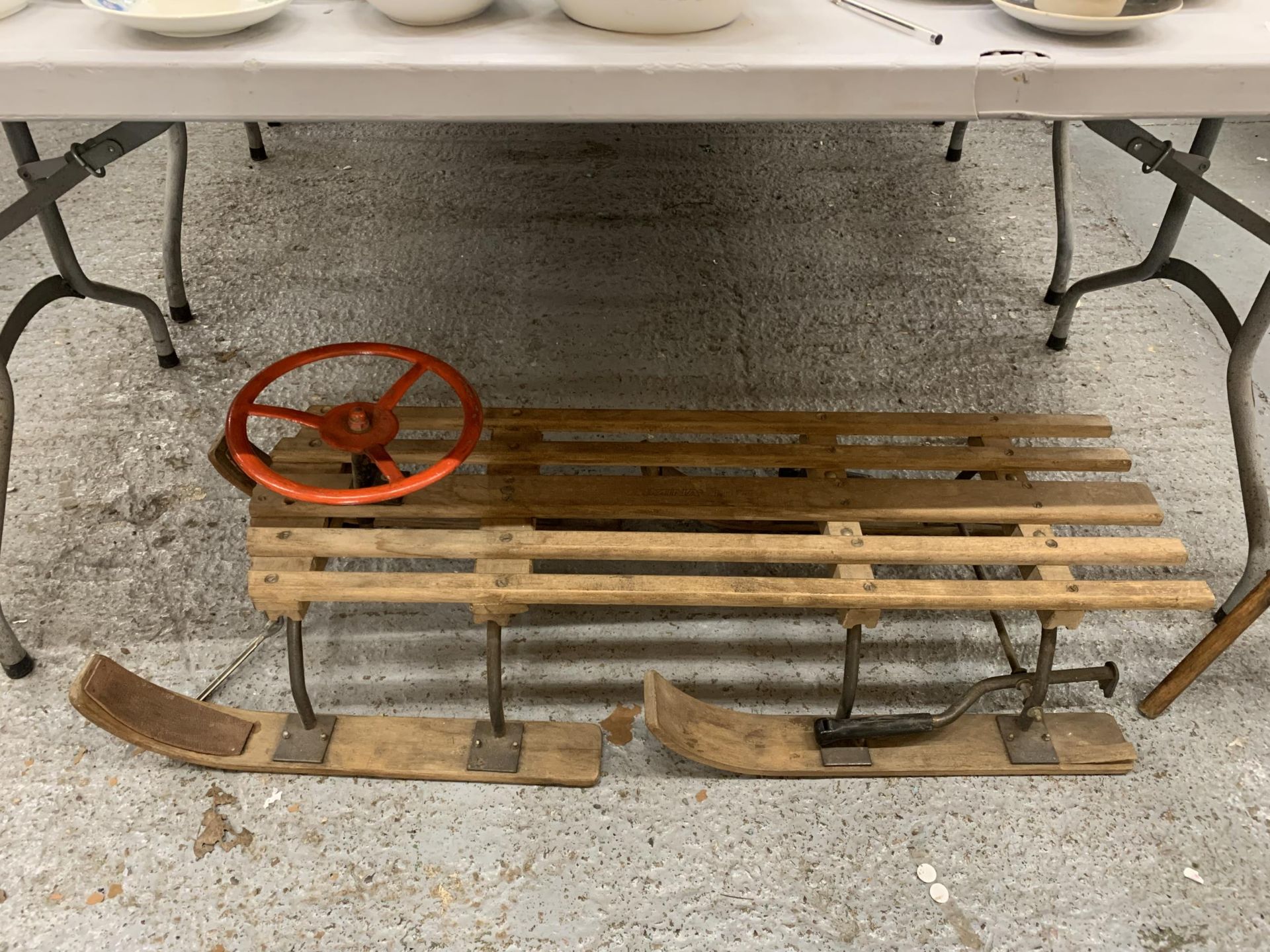 A VINTAGE WOODEN SLEDGE WITH A STEERING WHEEL