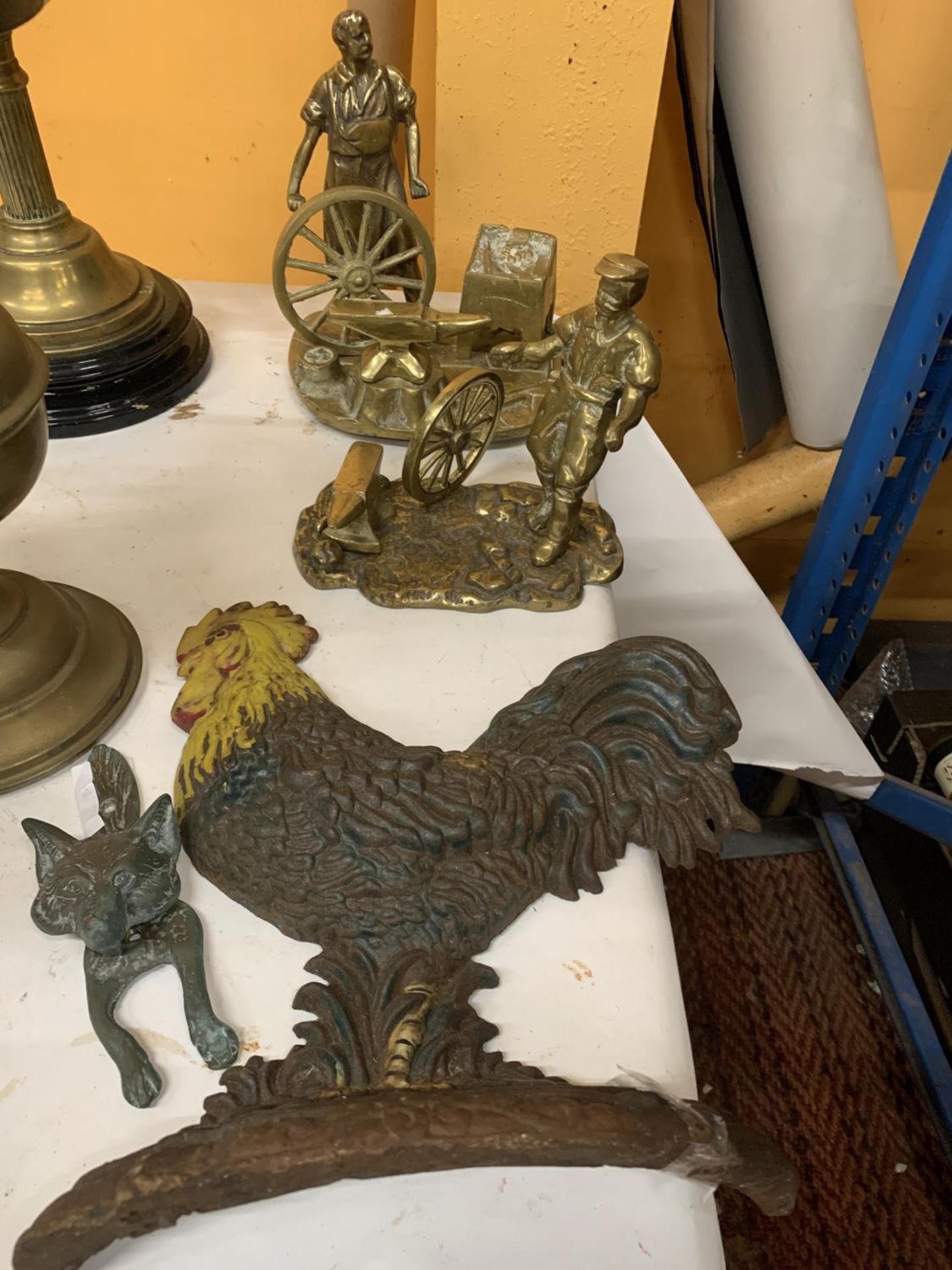 TWO HEAVY BRASS MODELS OF BLACKSMITHS, A VINTAGE CAST COCKEREL DOORSTOP AND A BRASS FOX DOOR KNOCKER