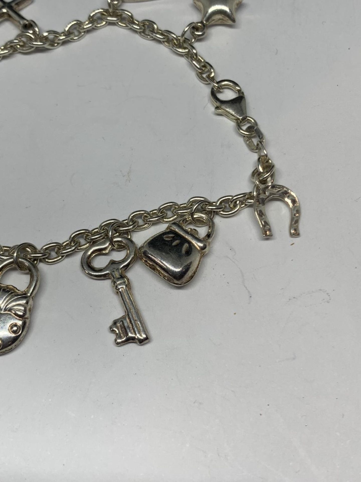 A SILVER BRACELET WITH ELEVEN CHARMS - Image 4 of 4