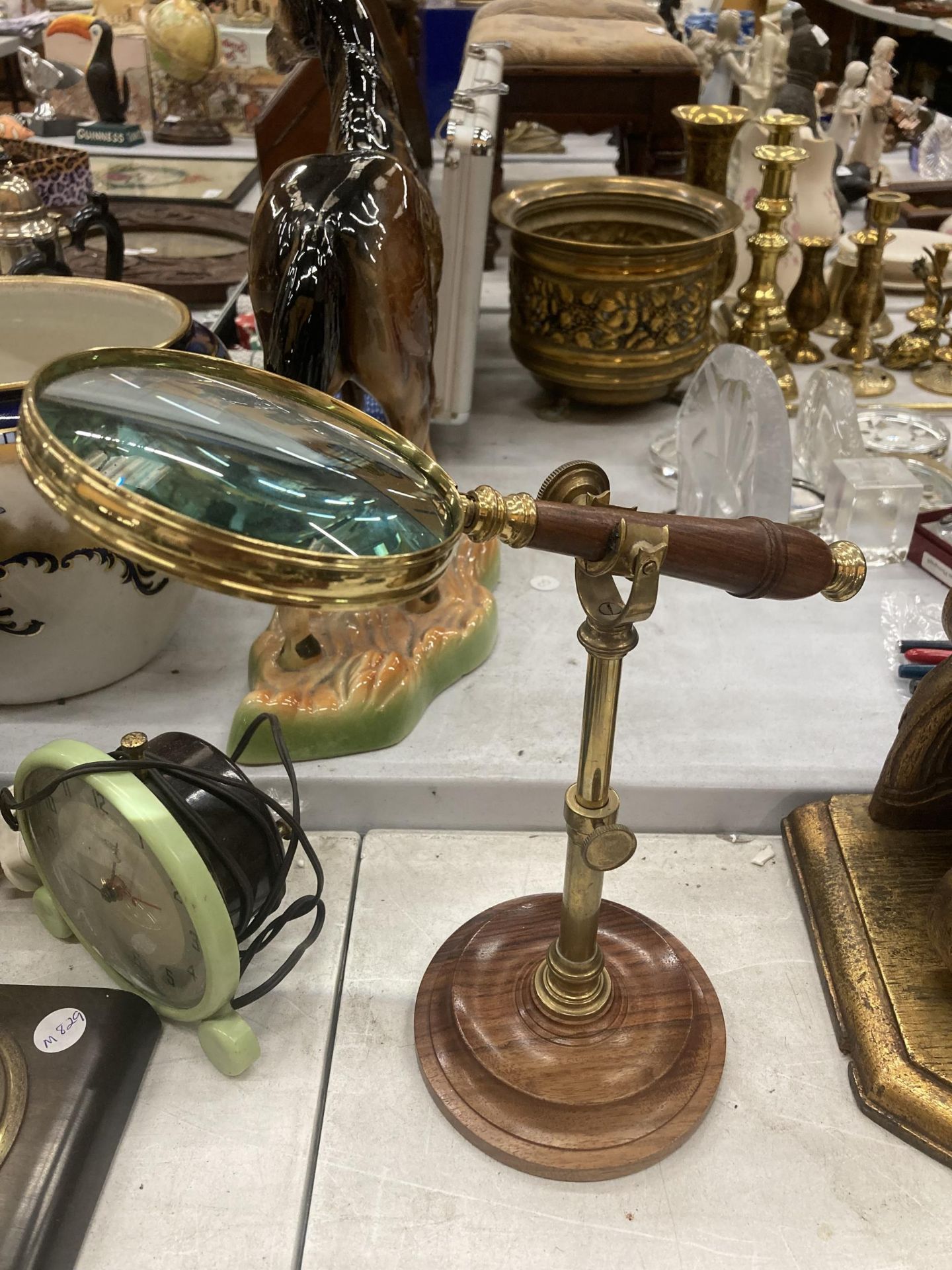 A VINTAGE STYLE MAGNIFYING GLASS ON A BRASS STAND AND WOODEN BASE HEIGHT APPROX 26CM