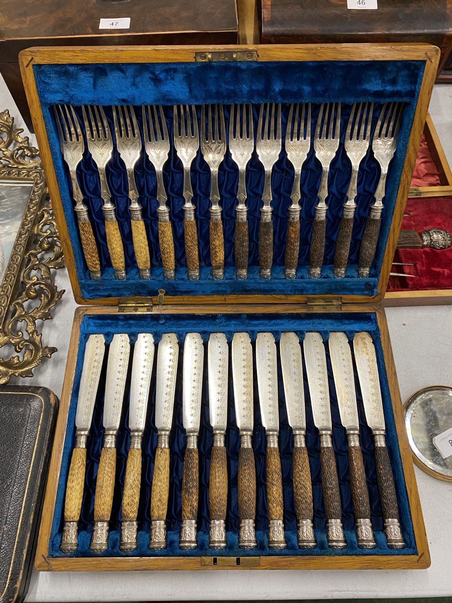 A VINTAGE OAK CASED CANTEEN OF HORN HANDLED CUTLERY WITH HALLMARKED SILVER FERRULES