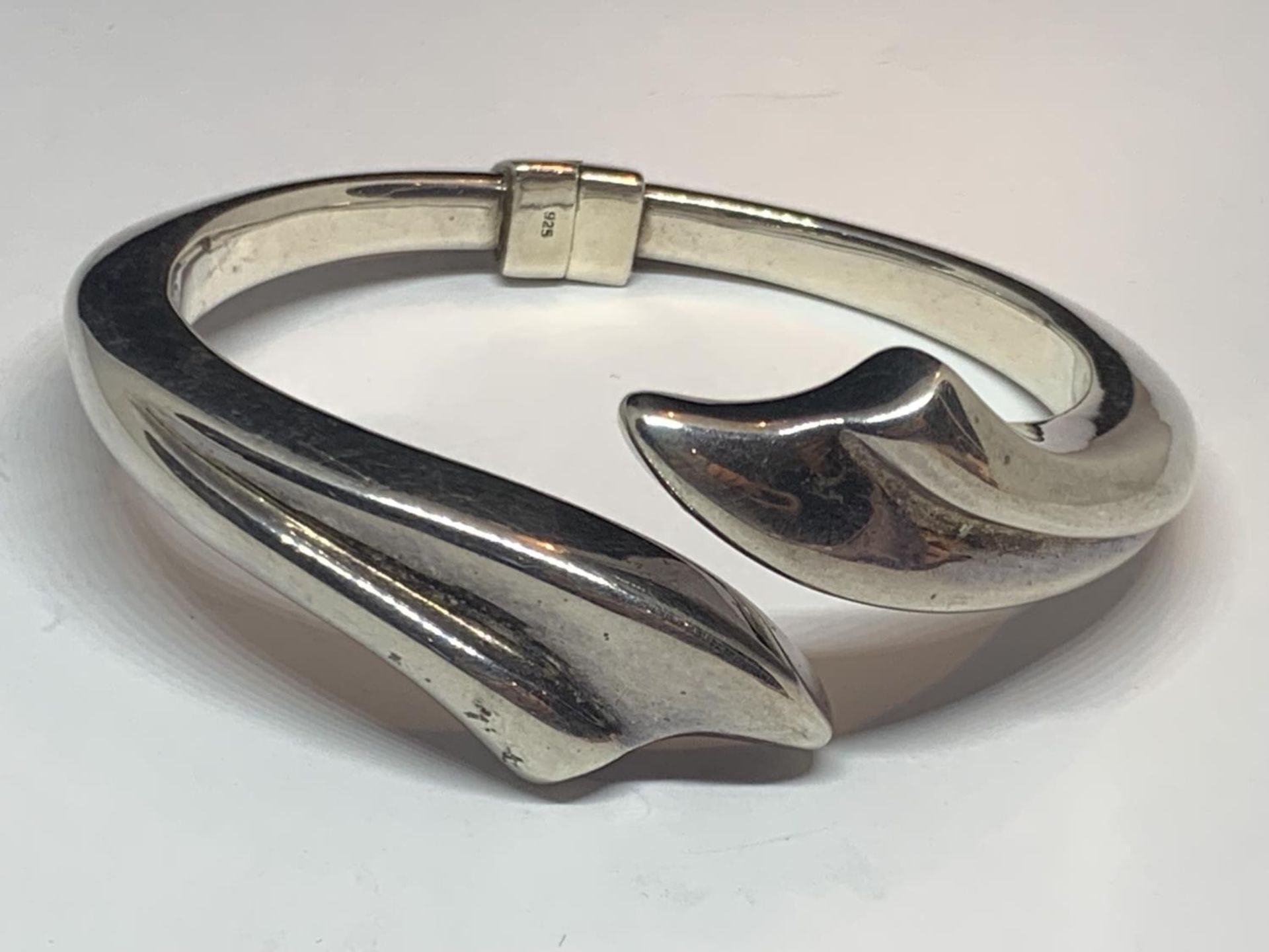 A DESIGNER SILVER BANGLE MARKED ACE