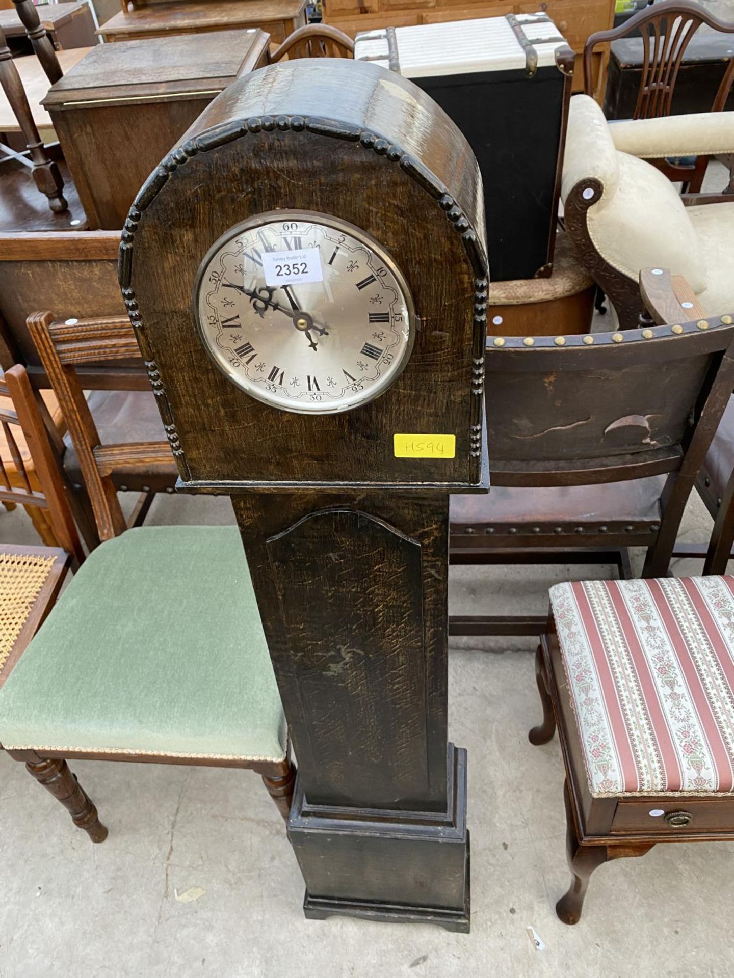 AN OAK GRANDMOTHER CLOCK WITH QUARTZ MOVEMENT