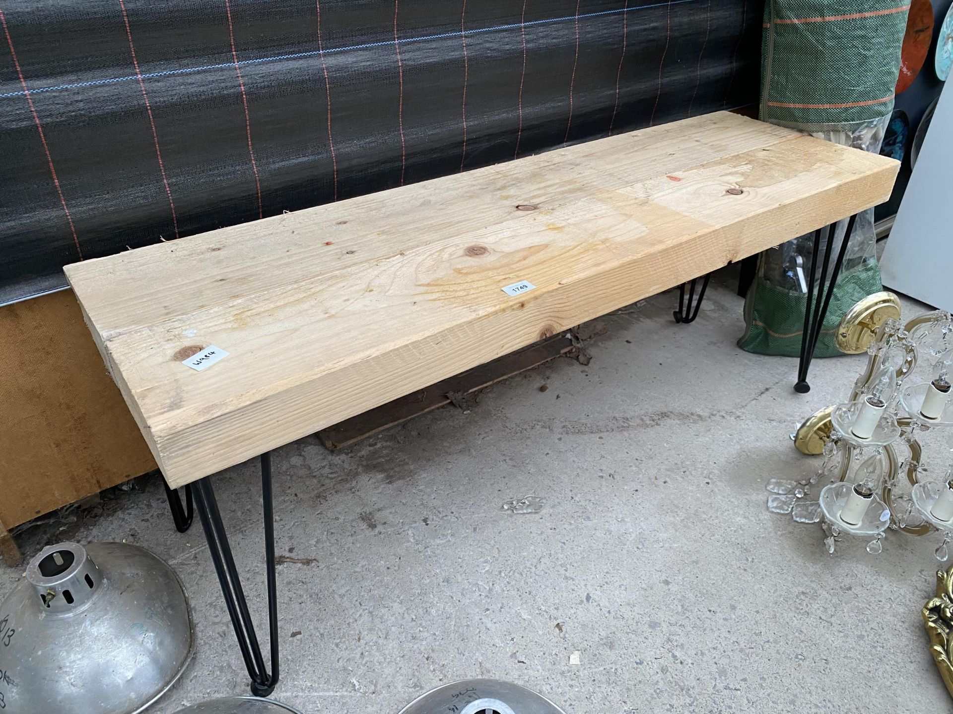 A WOODEN PLANK TOPPED BENCH WITH METAL LEGS