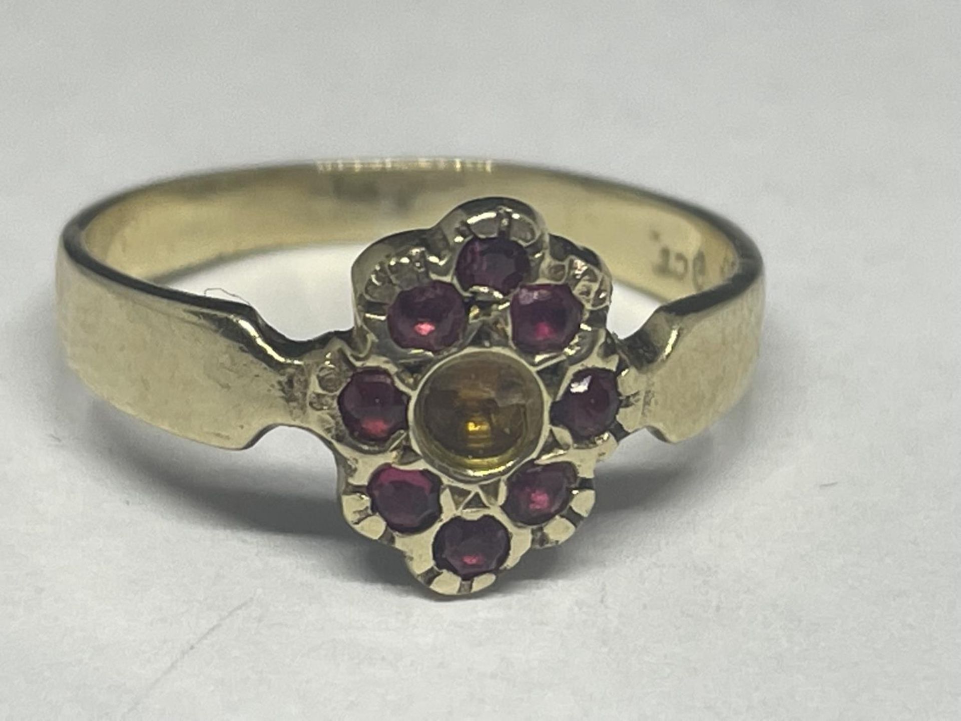 A 9 CARAT GOLD RING WITH WITH EIGHT RED STONES (CENTRE STONE MISSING) SIZE K GROSS WEIGHT 1.58 GRAMS