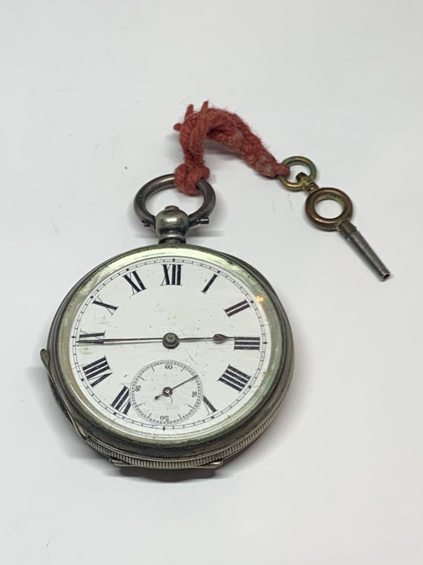 A .900 GRADE SILVER OPEN FACED POCKET WATCH WITH KEY