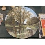A HANDPAINTED SIGNED CHARGER OF A RIVER SCENE DIAMETER 33.5CM