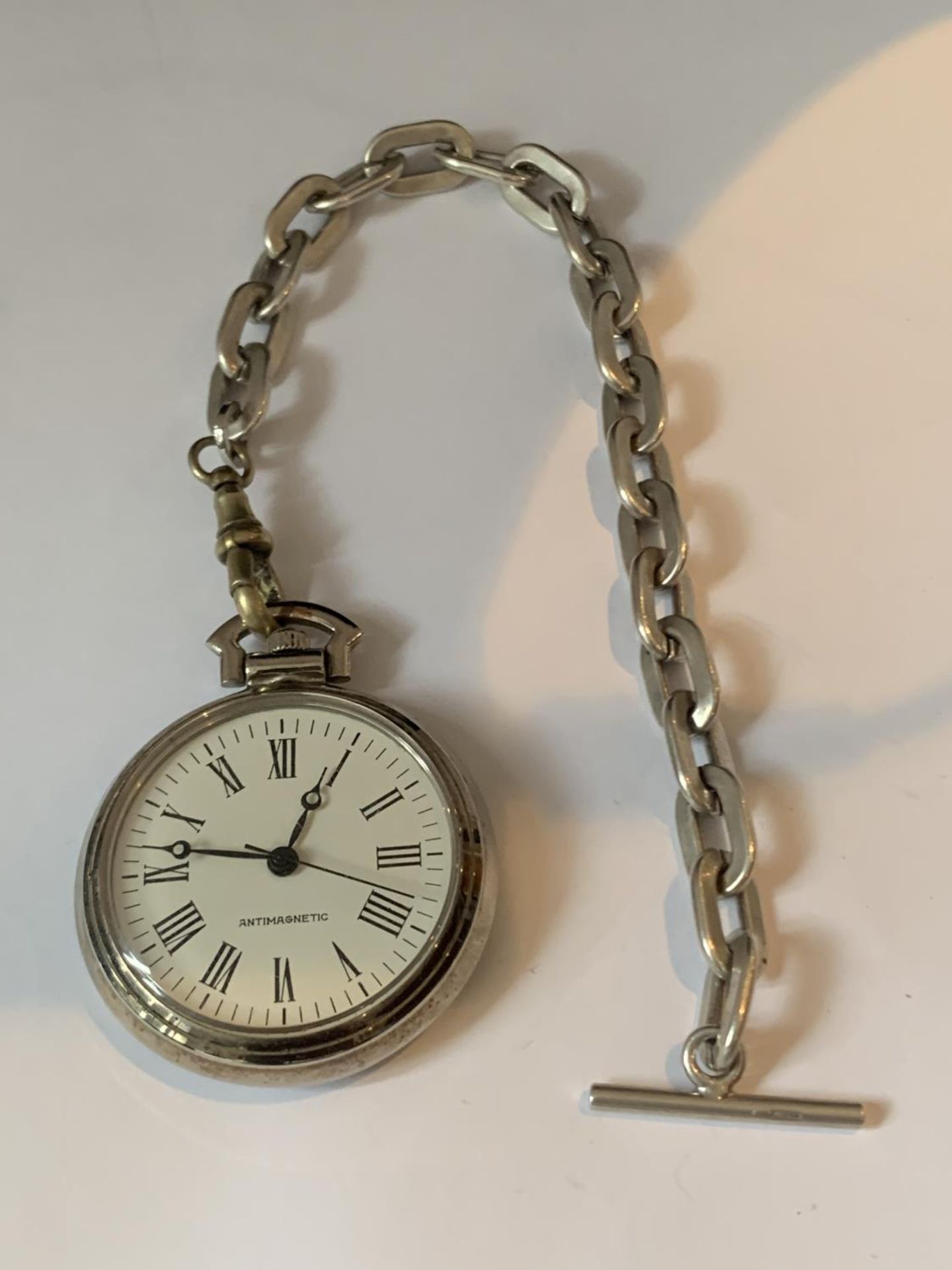 A POCKET WATCH WITH SILVER CHAIN