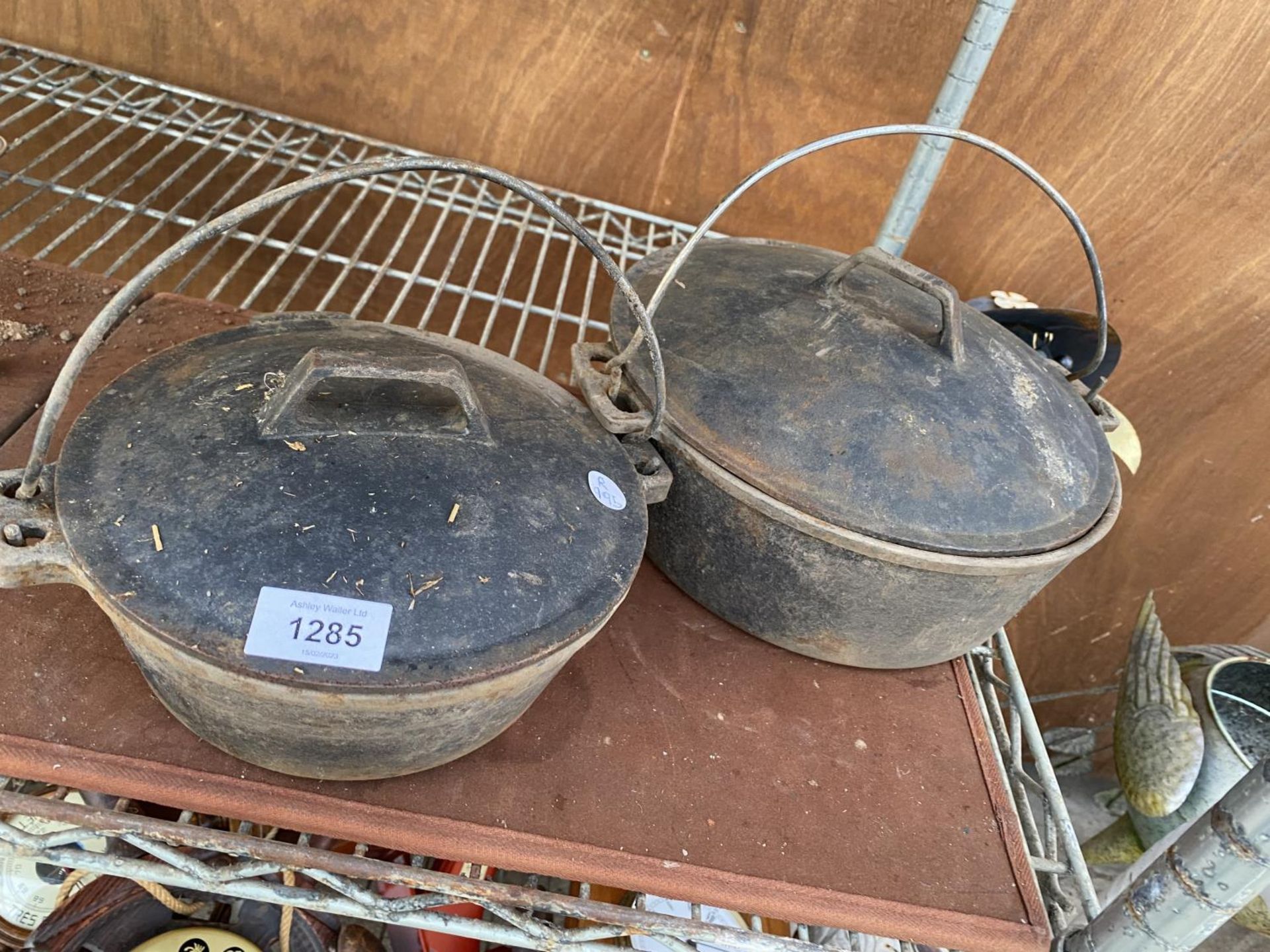 TWO CAST IRON LIDDED COOKING POTS