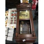 A MAHOGANY FRAMED WALL CLOCK WITH BEVELLED GLASS DOOR, PENDULUM AND KEY IN NEED OF SOME