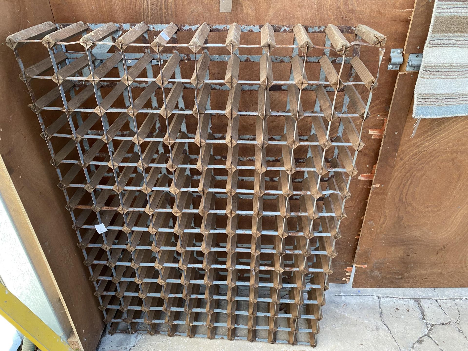 A WOODEN AND METAL 140 BOTTLE WINE RACK