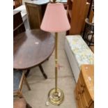 A SMALL BRASS STANDARD LAMP COMPLETE WITH SHADE