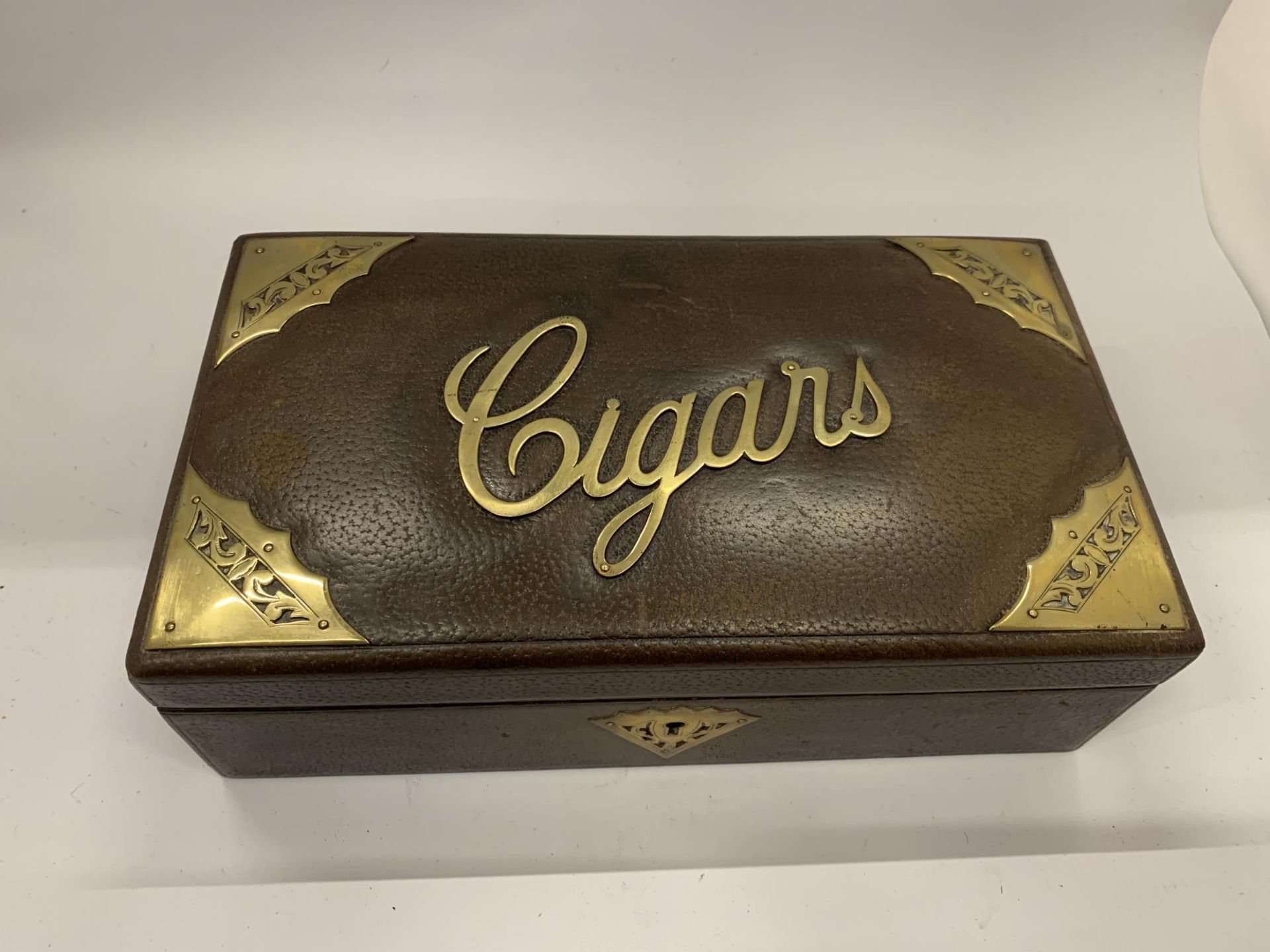 A VINTAGE LEATHER AND BRASS CIGAR BOX