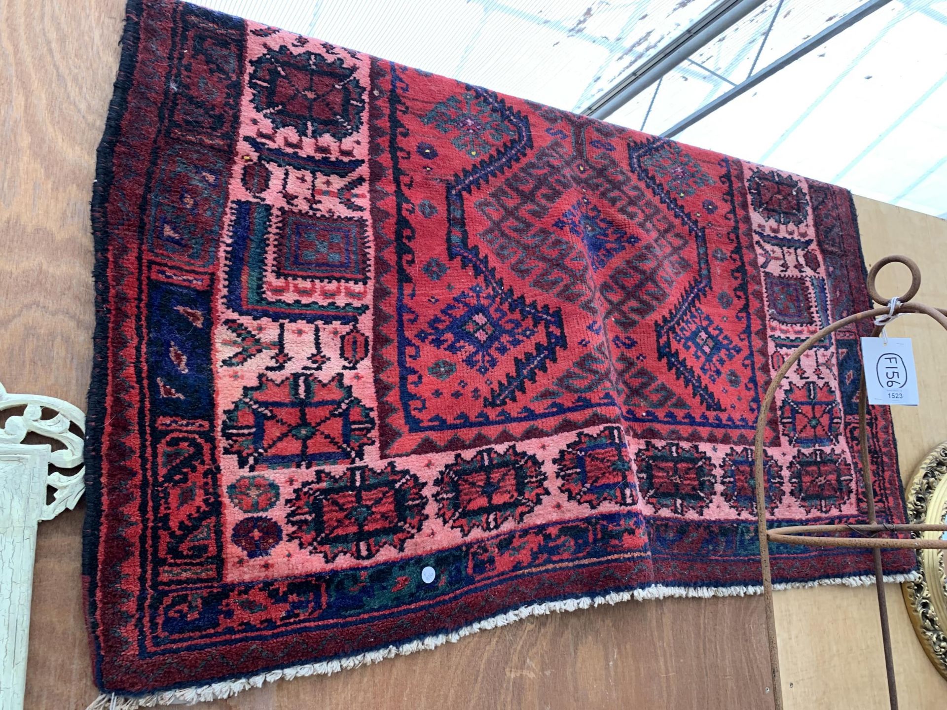 A RED PATTERNED FRINGED RUG