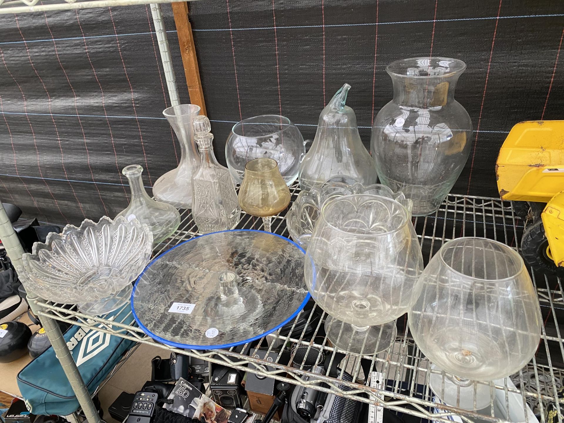 AN ASSORTMENT OF GLASS WARE TO INCLUDE VASES, DECANTORS AND A CAKE STAND ETC